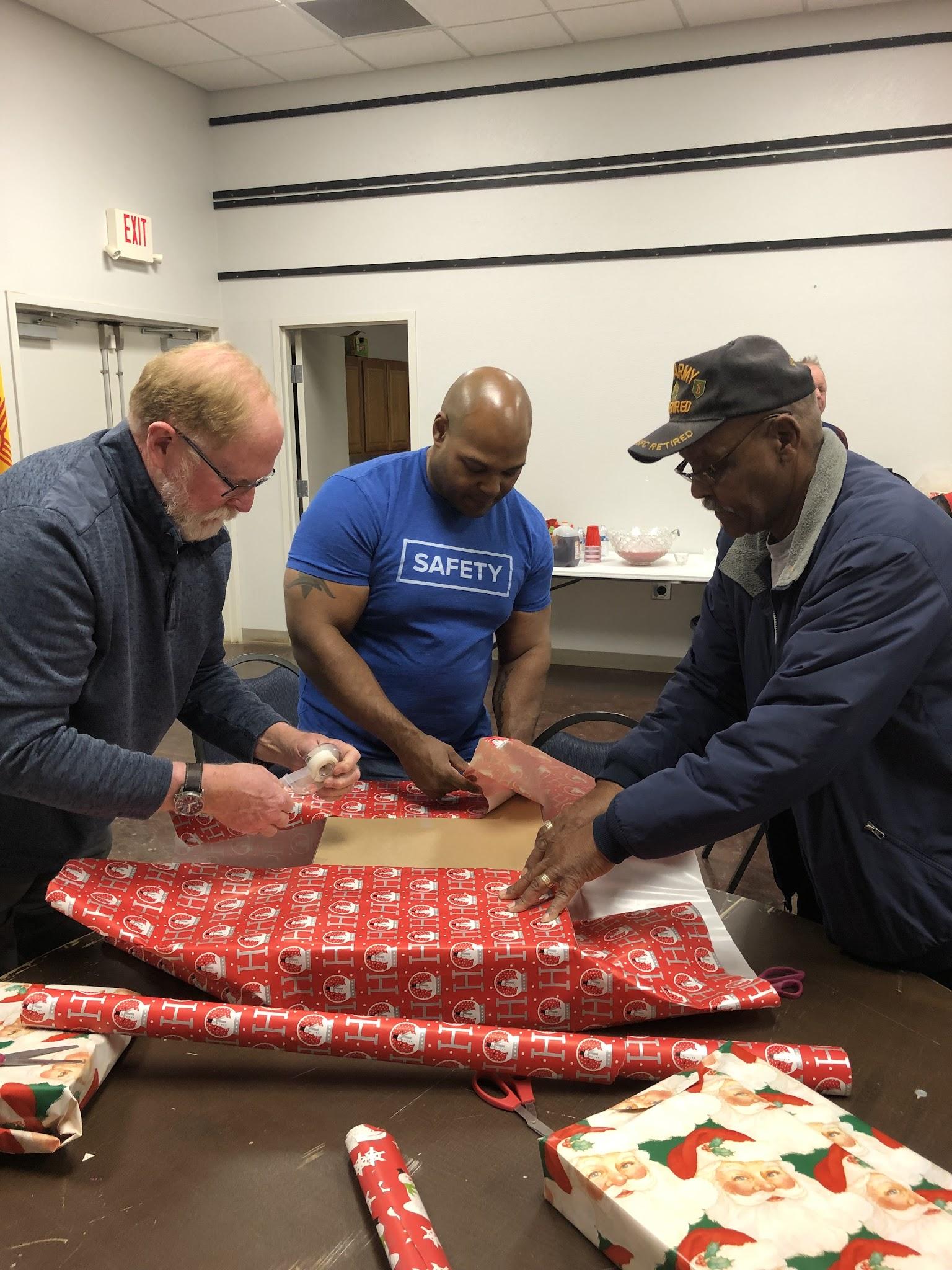 Members working together to wrap gifts during a lodge activity